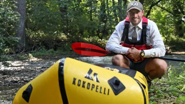 George Bullard sitting behind a yellow kayak