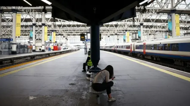 A commuter waits on a platform at Waterloo station, 23 June 2022