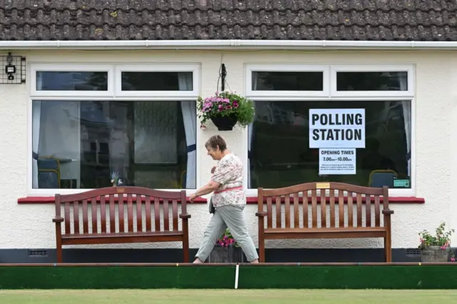 Woman passing a polling station in Seaton in East Devon