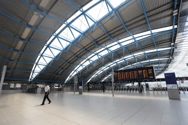 A man walks through an empty concourse in Waterloo Station