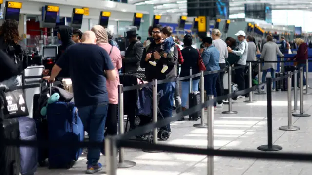 Passengers queue for check-in desks at Heathrow airport