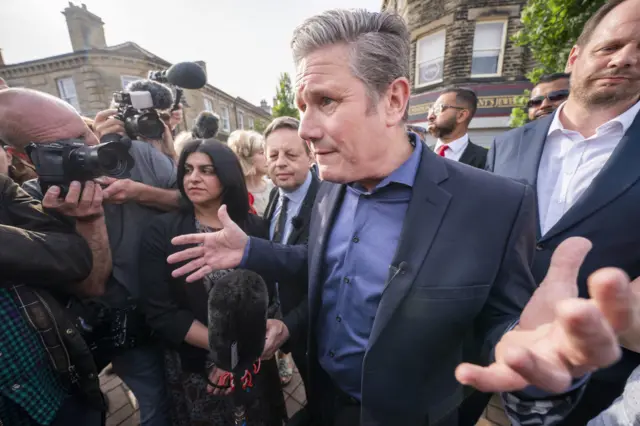 Sir Keir Starmer surrounded by journalists and activists