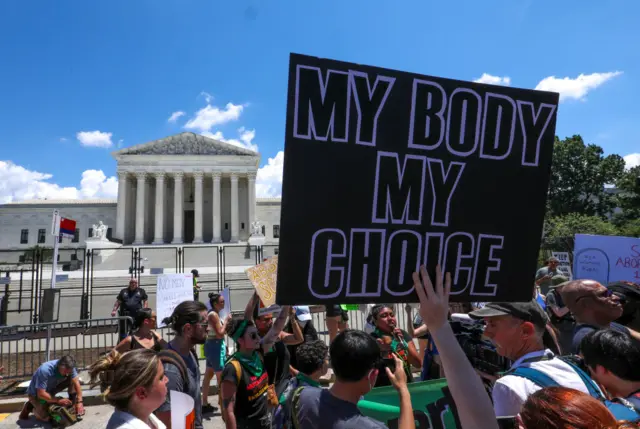 A woman holds up a  pro-choice sign in front of the US Supreme Court in Washington DC