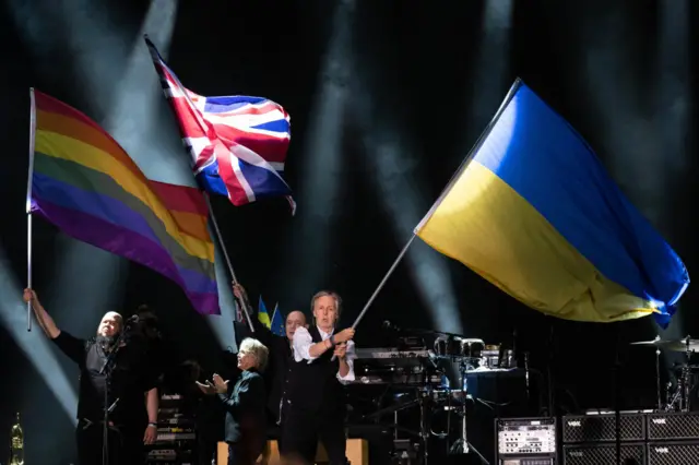 Paul McCartney waves a Ukrainian flag on stage at Glastonbury