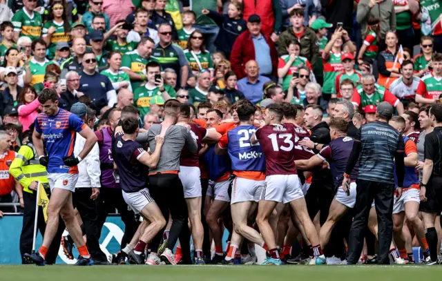 Players and staff from both teams in a mass brawl after Rian O'Neill's last-gasp equaliser