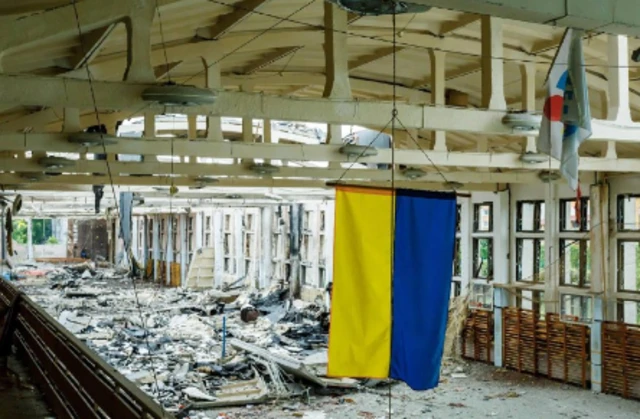 Ukraine's blue-and-yellow national flag in a destroyed sports complex in Kharkiv, north-eastern Ukraine