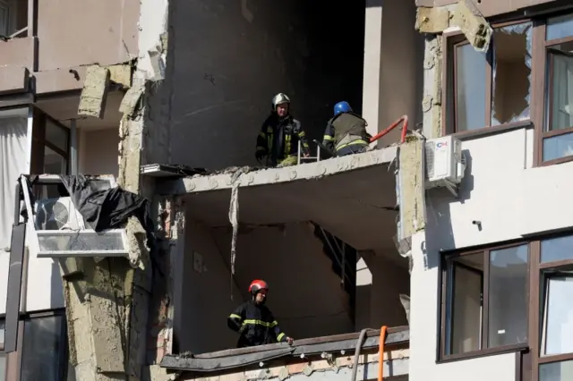 Firefighters work in a residential building damaged by a Russian missile strike