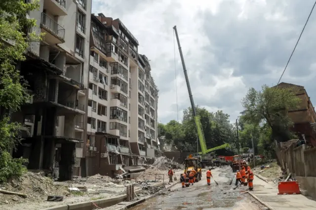 Emergency servicce workers at the site of a Russian missile attack on a residential building in Kyiv