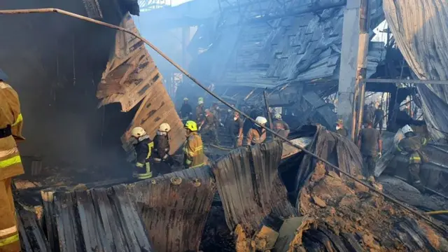 Firefighters searching the wreckage of the shopping center in Kremenchuk