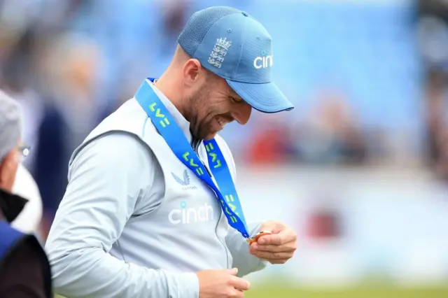 Jack Leach looking at his Player of the Match medal