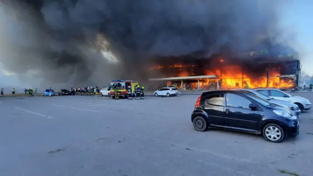 Firefighters tackle the fire at the Kremenchuk shopping centre