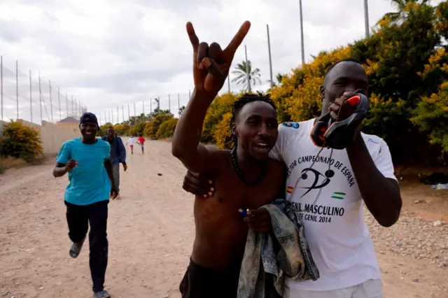 Migrants celebrate the jumping of the Melilla fence, June 24, 2022, in Melilla, Spain.