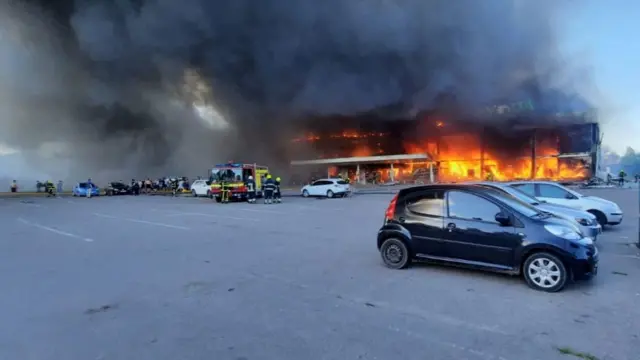 A shopping centre on fire after it was hit by a Russian missile strike