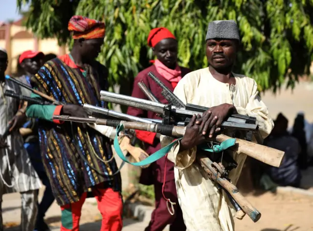 Members of the Yansakai vigilante group bring their weapons into the Zamfara State Government house as they members surrendered more than 500 guns to the Zamfara State Governor,