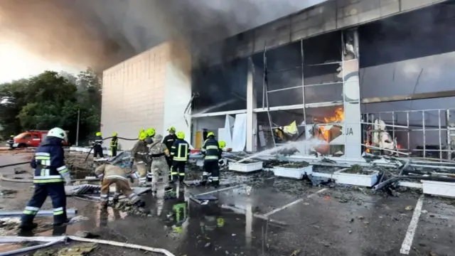 Firefighters tackle the fire at the Kremenchuk shopping centre