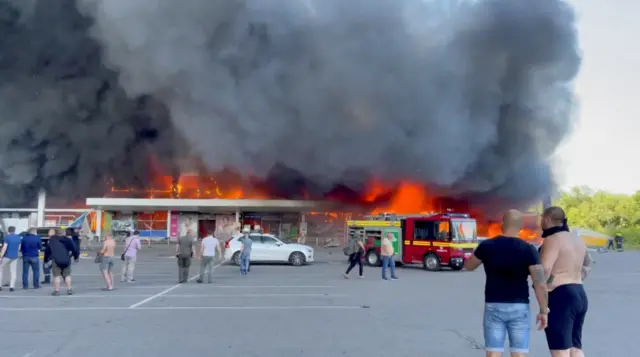 Smoke rises from a shopping mall hit by a Russian missile strike in Kremenchuk, Ukraine,