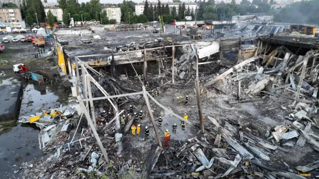 Rescue workers at a site of a shopping mall hit by a Russian missile strike in Kremenchuk, Ukraine