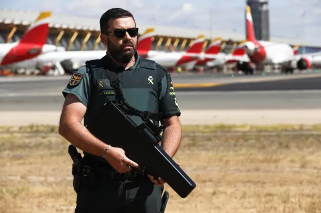 A Civil Guard officer stands guard near of the tarmac of Adolfo Suarez Madrid Barajas international airport in Madrid, Spain