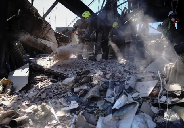 Rescuers work at a site of a shopping mall hit by a Russian missile strike in Kremenchuk