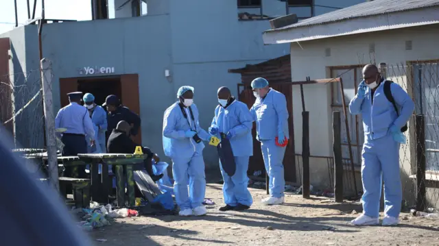 Forensic personnel investigate after the deaths of patrons found inside the Enyobeni Tavern