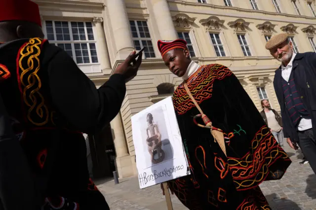 Protesters from Cameroon seeking the return of the Ngonnso statue stand outside the Humboldt Forum during the opening of the Humboldt's Ethnological Museum and the Museum for Asian Art on September 22, 2021 in Berlin