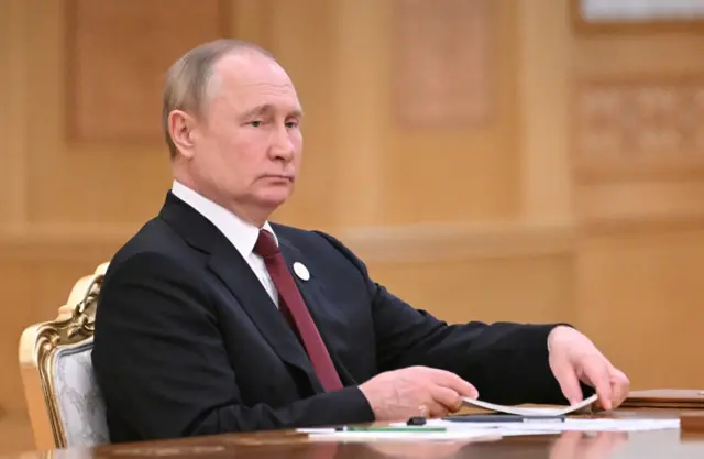 President Putin sits at a table during a summit