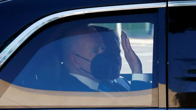 Joe Biden waves from a car on his way to attend the Nato summit in Madrid,