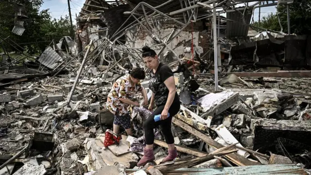 Residents look for belongings in the rubble of their home after a Russian strike in the eastern Ukrainian region of Donbas