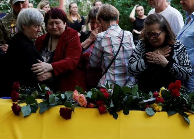 Family and friends console the mother of a Ukrainian soldier killed by an antitank mine during a reconnaissance mission in the Kharkiv region