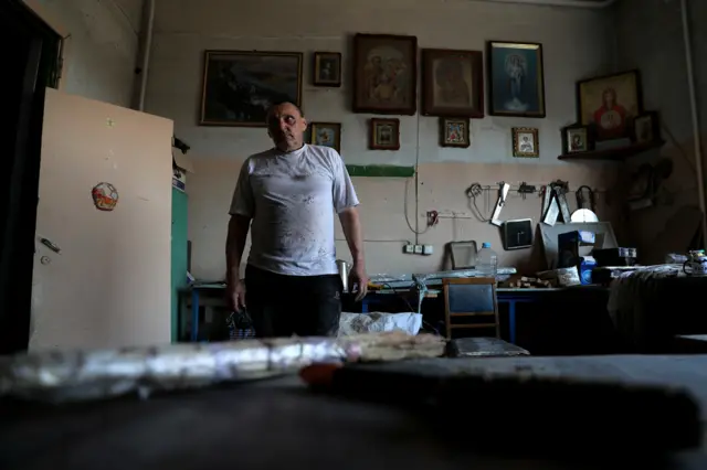 A worker at a wood warehouse on the outskirts of Kharkiv looks around following a Russian strike