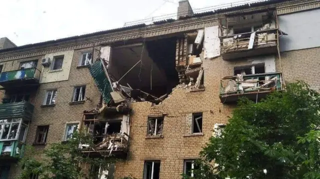 A Ukrainian building is pictured with a chunk of its front missing