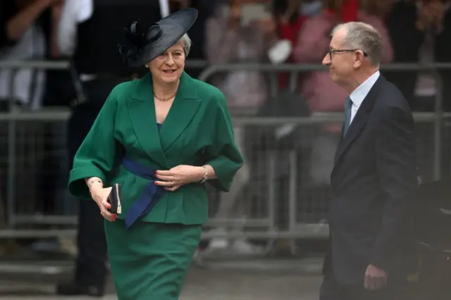 Former Conservative prime minister Theresa May (L), accompanied by her husband Philip,