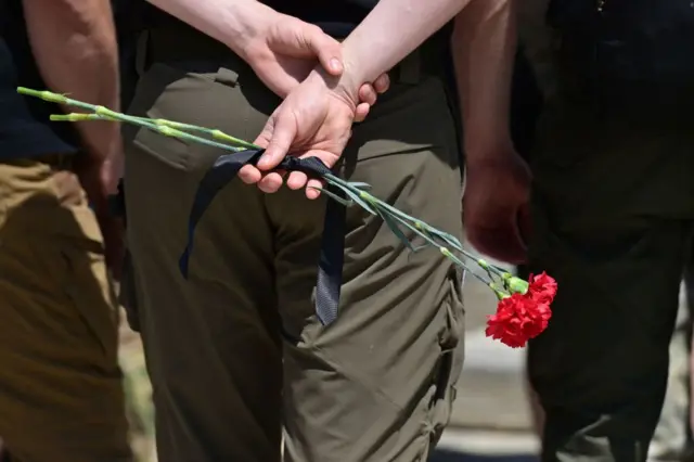 A soldier holds a red carnation as he attends the funeral of a Ukrainian soldier at the St Michael's Golden-Domed Monastery in Kyiv,