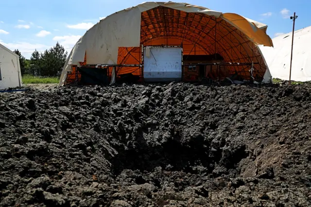 A crater in front of an airfield hangar on the outskirts of Kharkiv