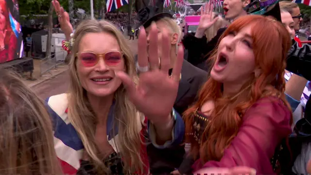 Kate Moss waves to viewers from the top of the '90s bus