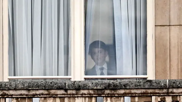 Prince George is seen at a palace window