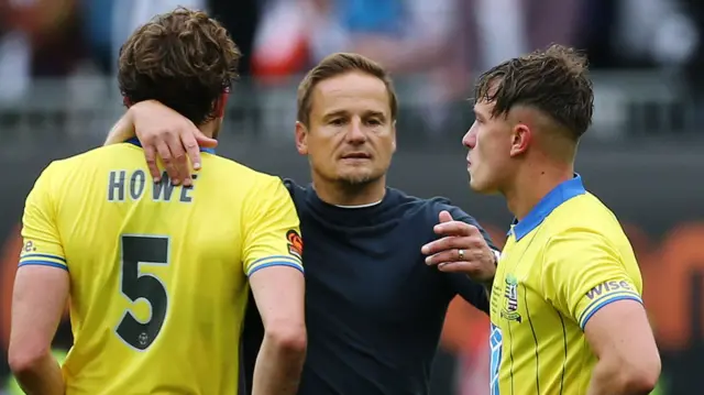 Neal Ardley consoles his players