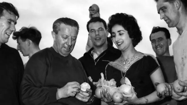 Wales' players and manager Jimmy Murphy are presented with Israeli oranges