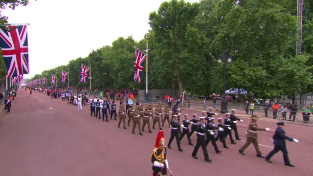 Military personnel march along the Mall