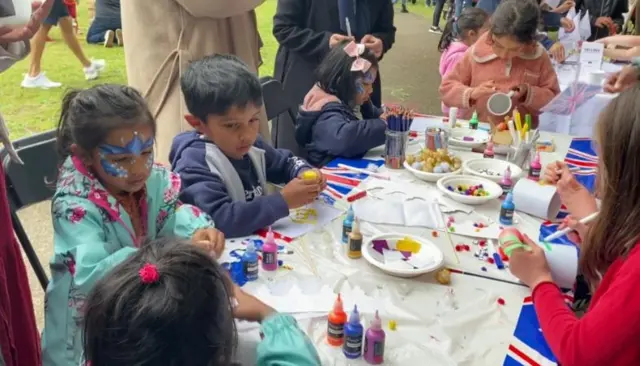 Children tucking into party food in Mile End