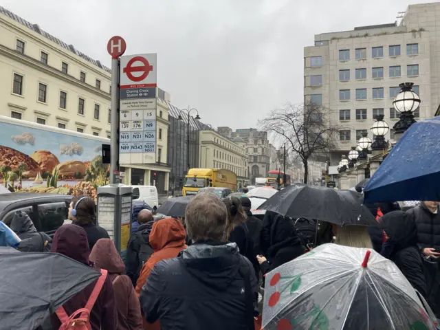 Commuters at bus stop during strike in March 2022