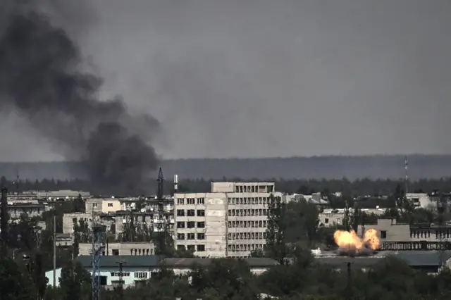A view of rooftops in Severodonetsk with smoke rising in the distance