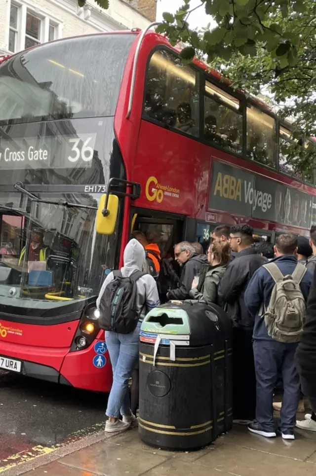People queue for a bus