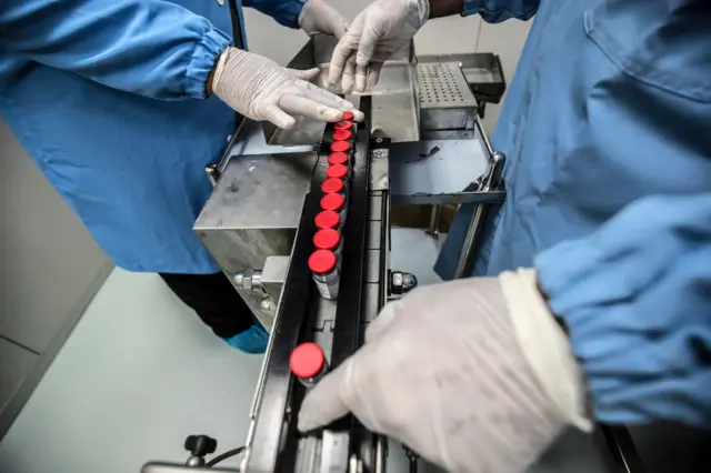 Laboratory workers supervise the production of vials of China's Sinovac vaccine against the coronavirus, produced by the Egyptian company VACSERA, in the capital Cairo, on September 1, 2021