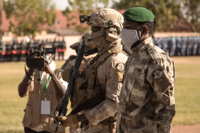 Transitional Malian President, Colonel Assimi Goïta (R) looks on after laying a wreath on the monument to the dead, during the ceremony celebrating the national day of the army, in Kati, on January 20, 2022.