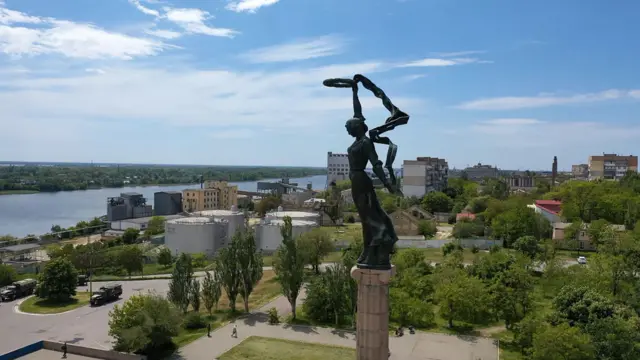 Cityscape of Kherson with a statue in the foreground