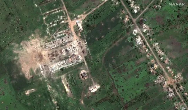 Satellite image of a huge crater near buildings