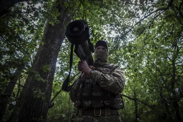 A Ukrainian serviceman keeps watch near the frontlines of Izyum