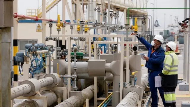 Workers at an energy terminal are seen monitoring gas levels