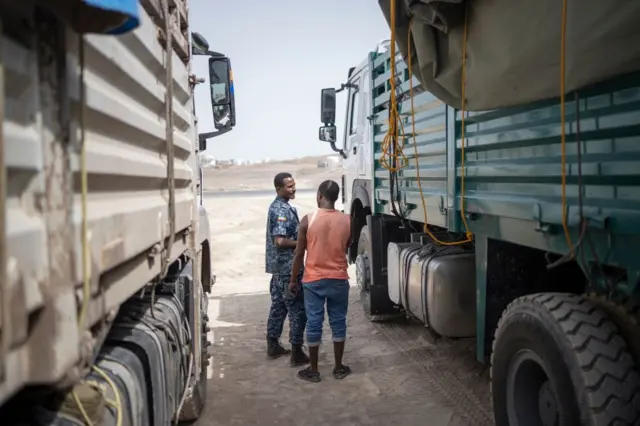 A member of the Ethiopia Federal Police inspect the cab of a truck at a security checkpoint where a 130 trucks aid convoy directed to Ethiopia's Tigray region